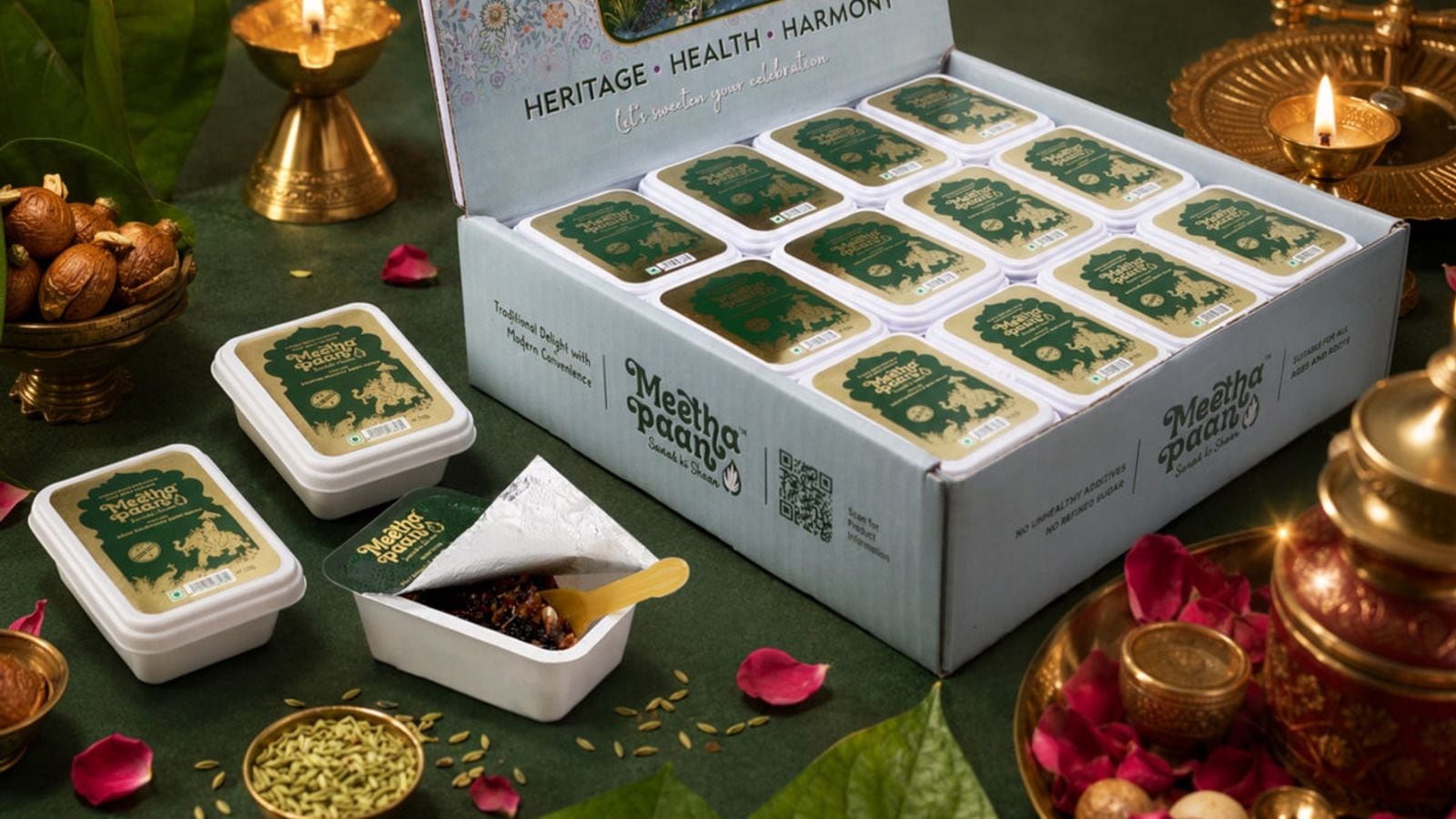 A Meetha Paan party box with individually packed portions on a festive table with brass diyas and rose petals